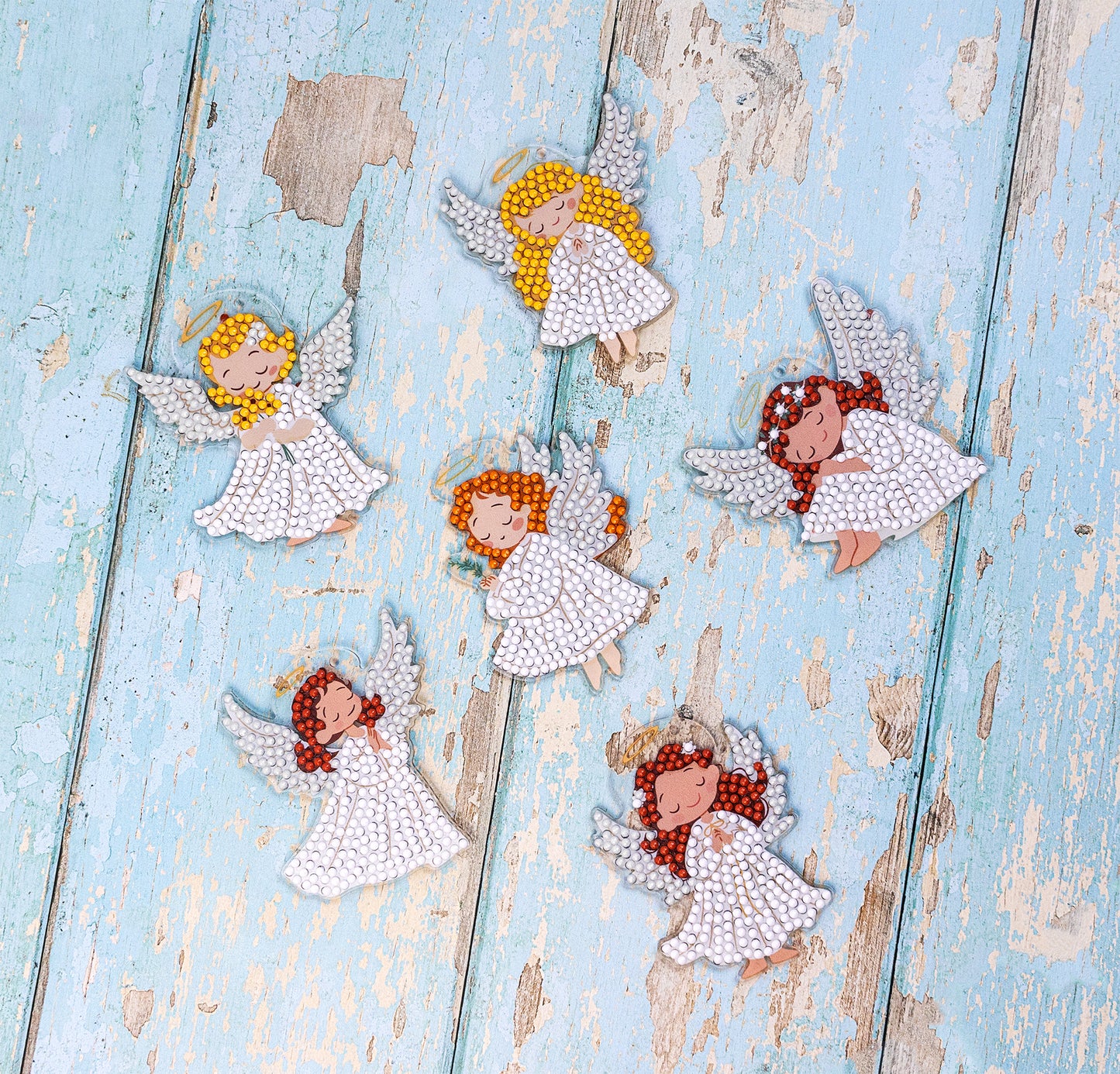 Decorative angel figurines with colorful hair on a rustic wooden surface, Dazzle Dots Diamond Art kit