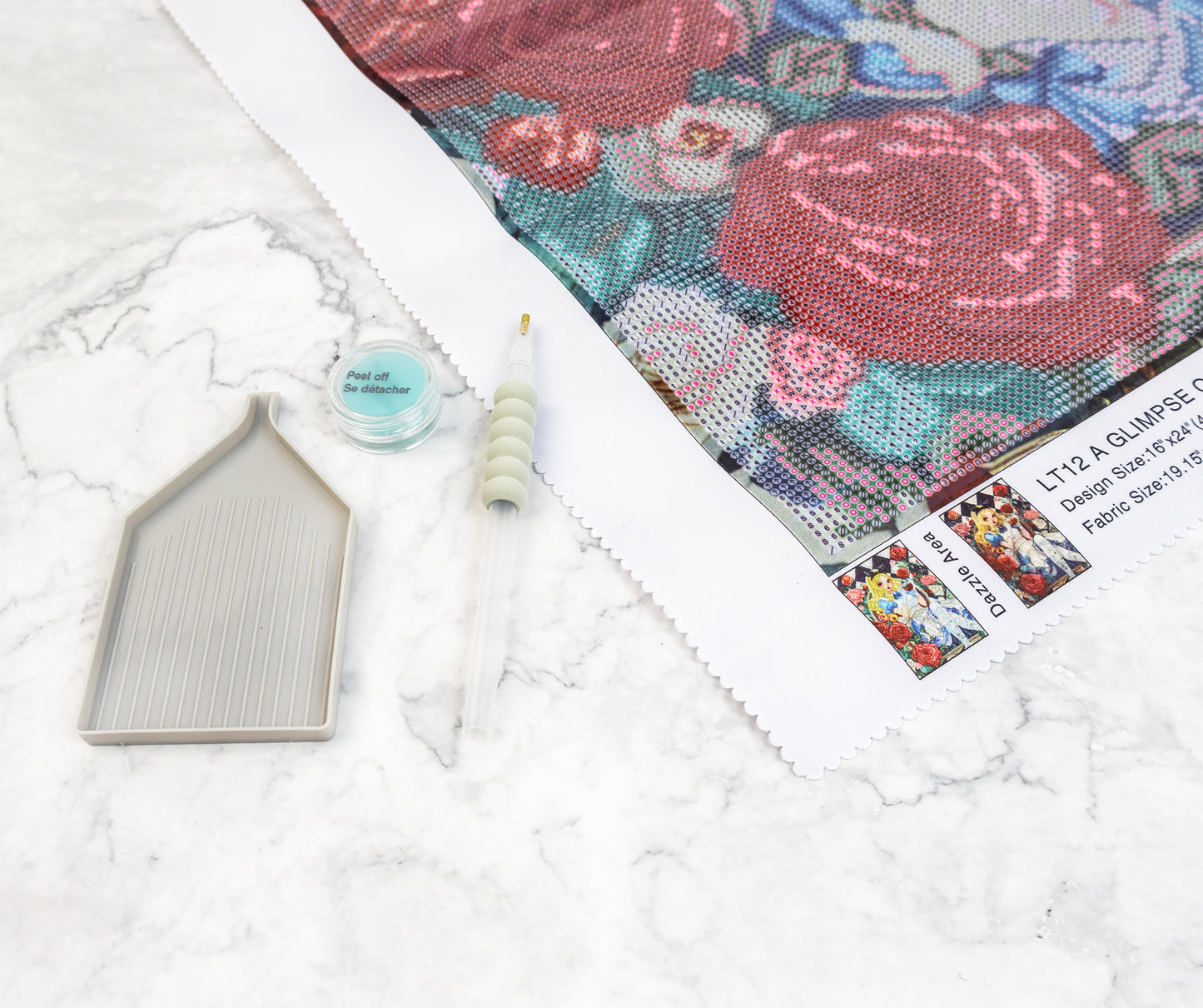Floral fabric swatch with a tray and small wax container on a white marble surface