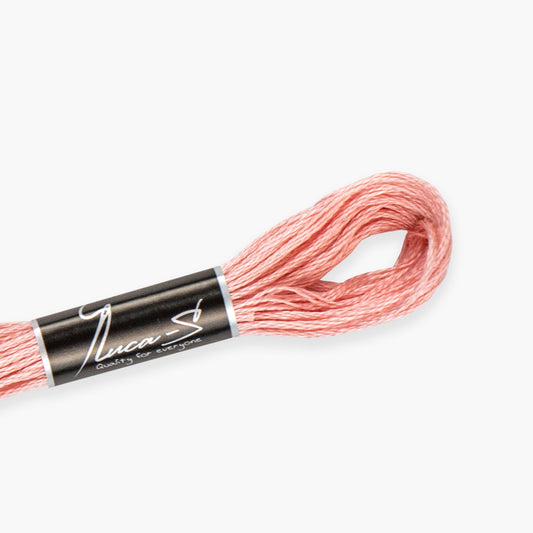 Skein of pink embroidery floss with a black and white label on a white background