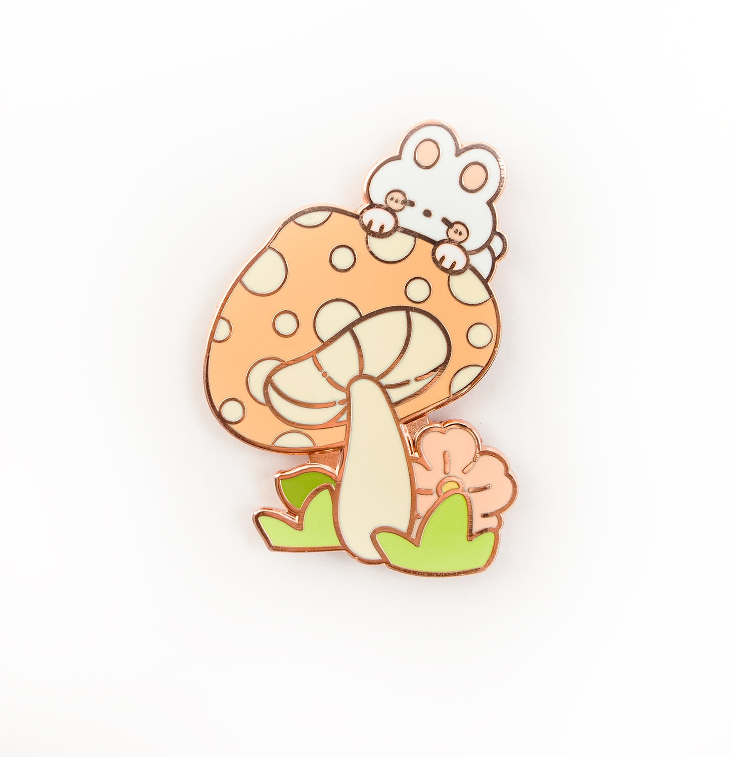 A cute enamel pin featuring a white mouse peeking out from behind a large orange mushroom with white spots, green leaves, and a small pink flower, set against a plain white background.