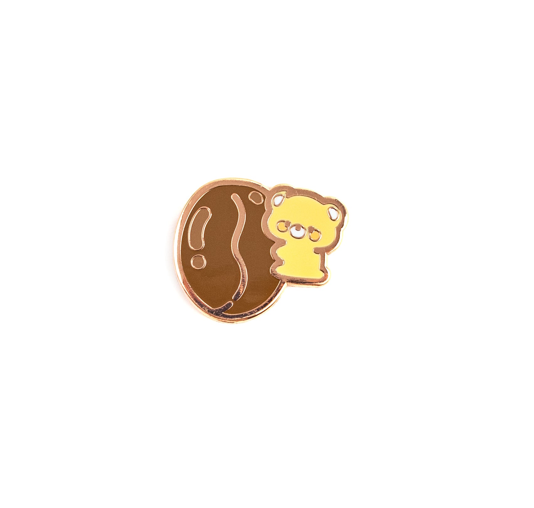 A small enamel pin featuring a yellow cartoon bear peeking from behind a brown oval shape with a wavy line detail, outlined in metallic rose gold, on a plain white background.