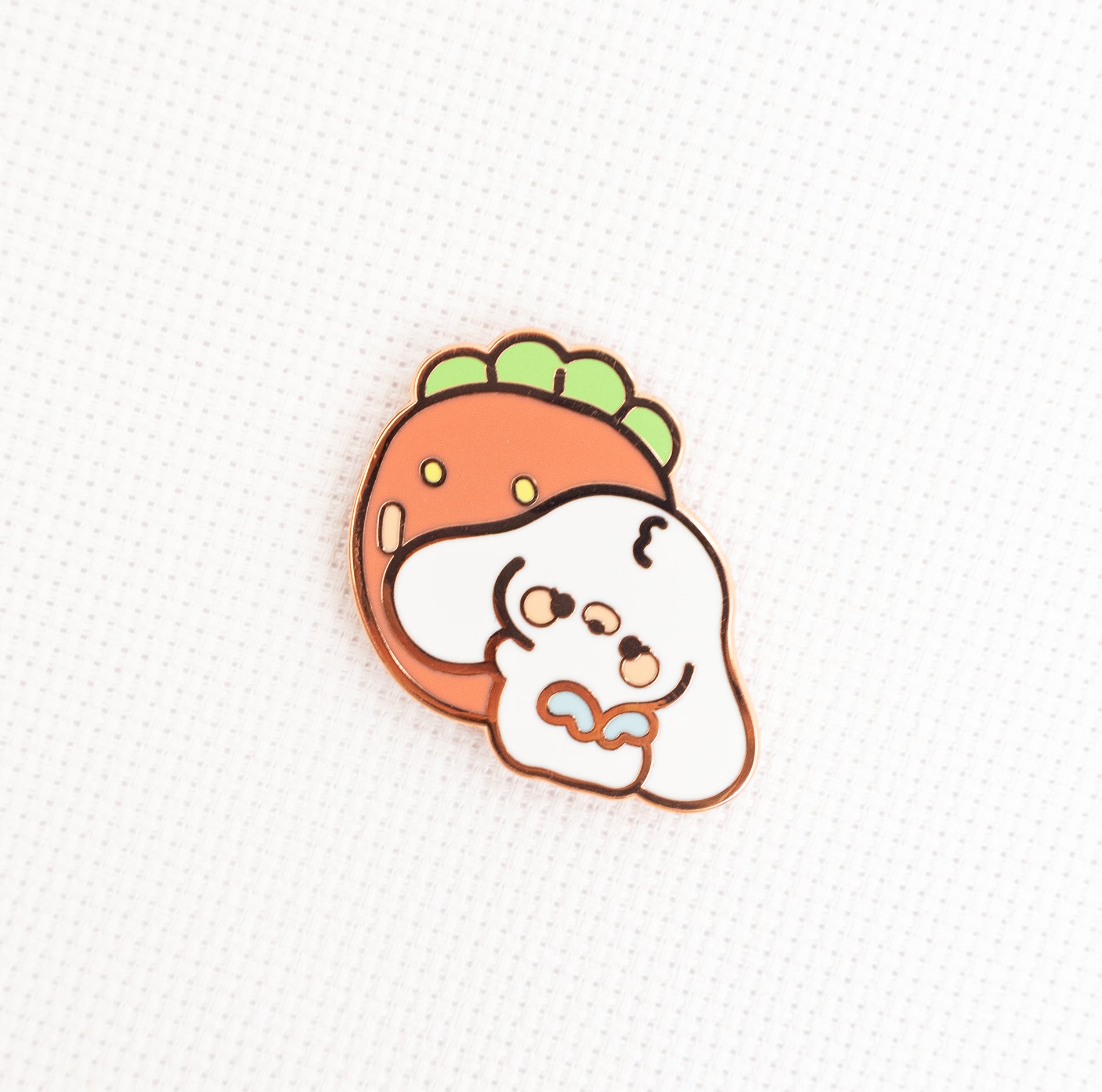 A cute cartoon enamel pin featuring a white dog character with a carrot-shaped head on a textured white background.