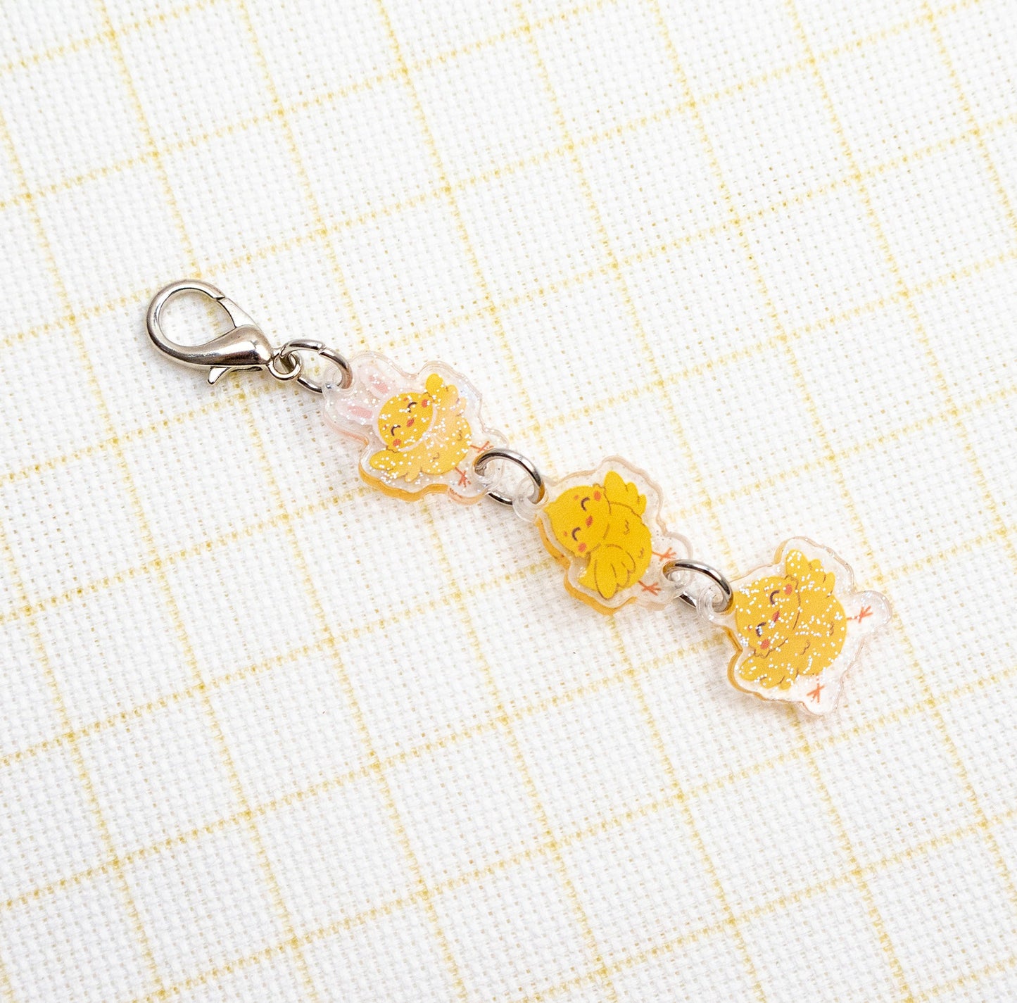 Keychain with yellow character charms on a grid background