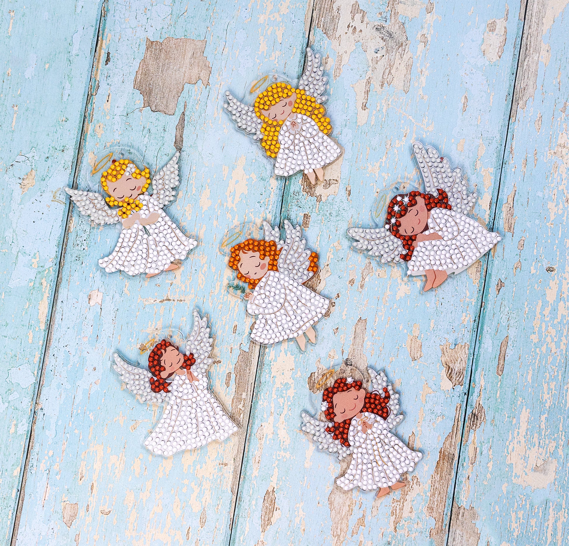 Decorative angel figurines with colorful hair on a rustic wooden surface, Dazzle Dots Diamond Art kit 