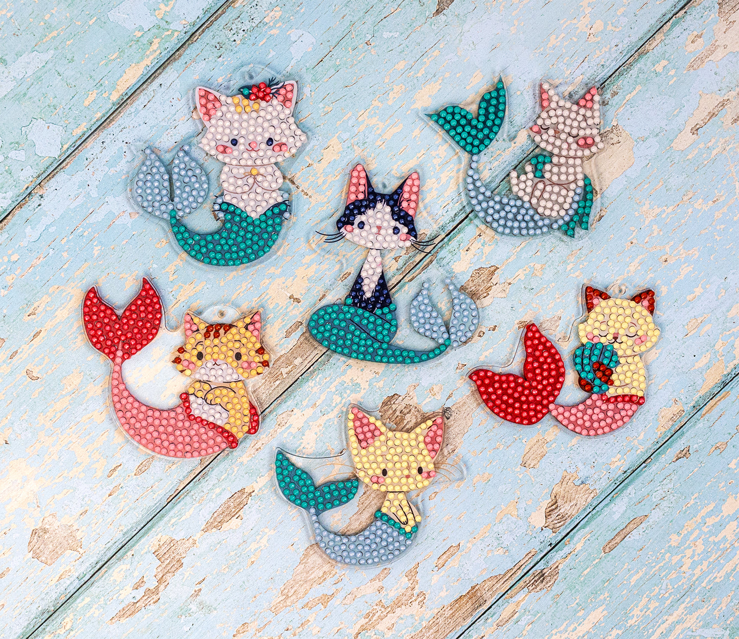 Set of cat-shaped mermaid figurines on a wooden surface