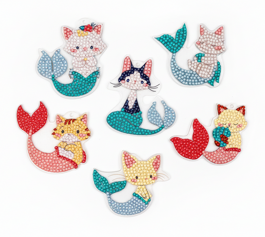 Set of colorful cat mermaid figurines on a white background