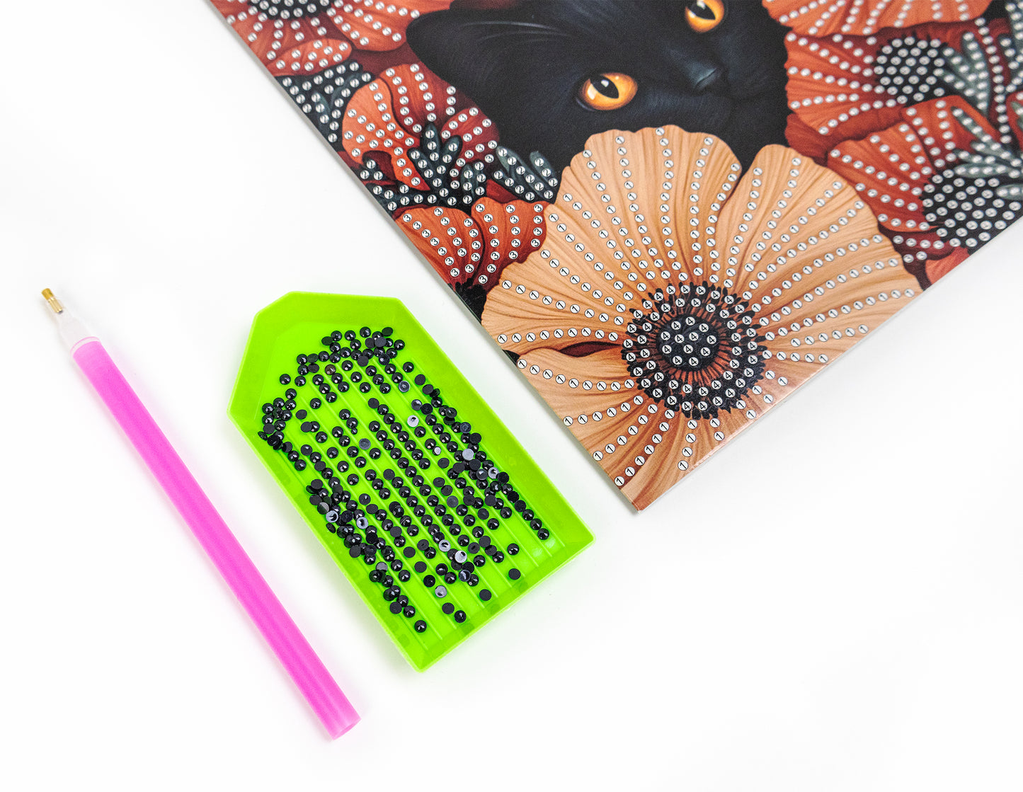 crystal art card with a black cat illustration, beads, and a pink pencil on a white background