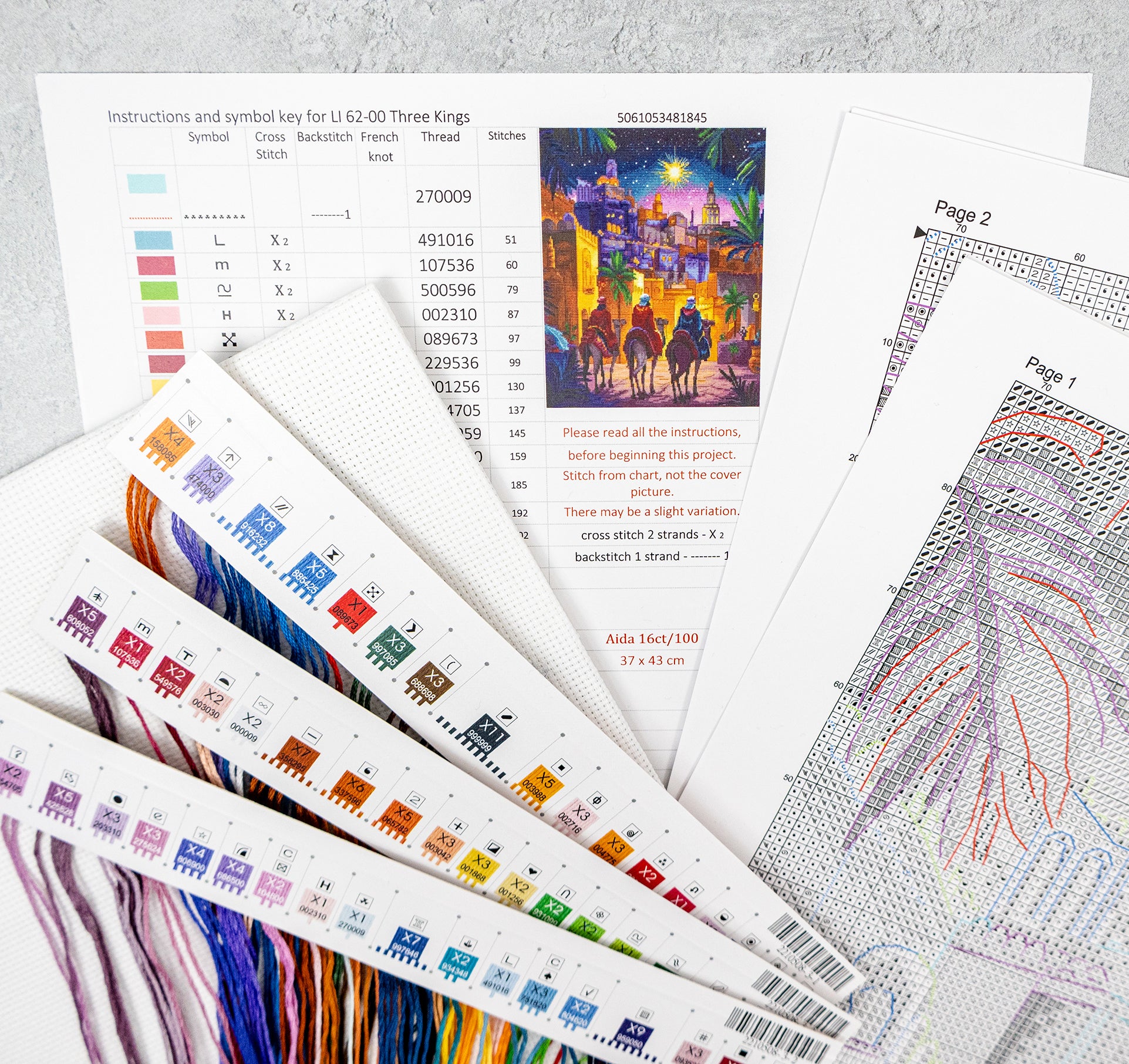 Embroidery pattern sheets with color swatches and designs on a textured surface