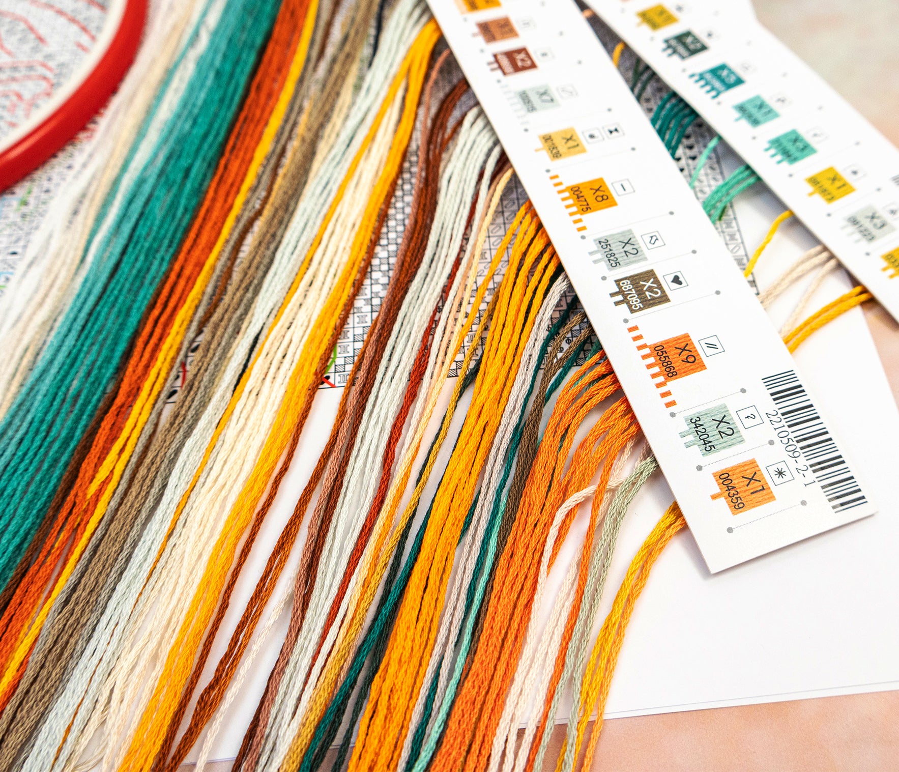 Colorful yarn strands with a set of stamps on a textured surface