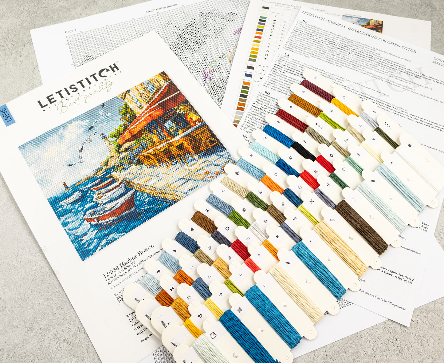 Embroidery thread set with color swatches and a painting of a harbor scene.