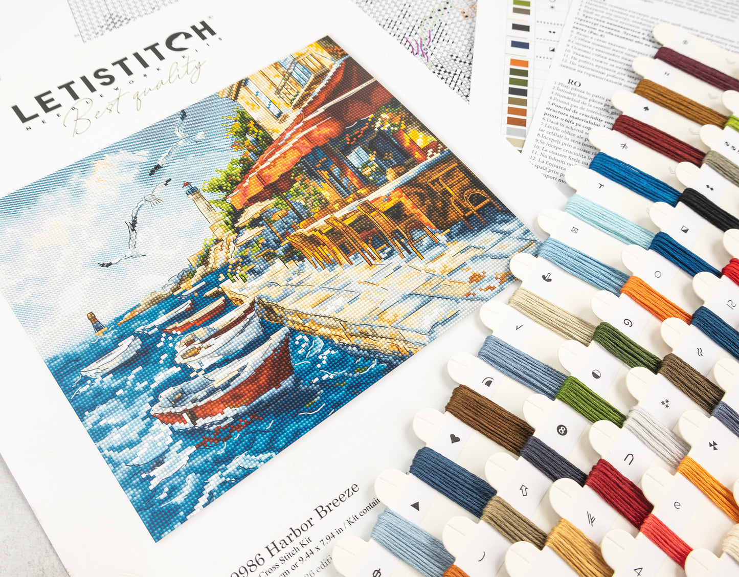 Cross-stitch kit with a scenic design and color swatches on a white background