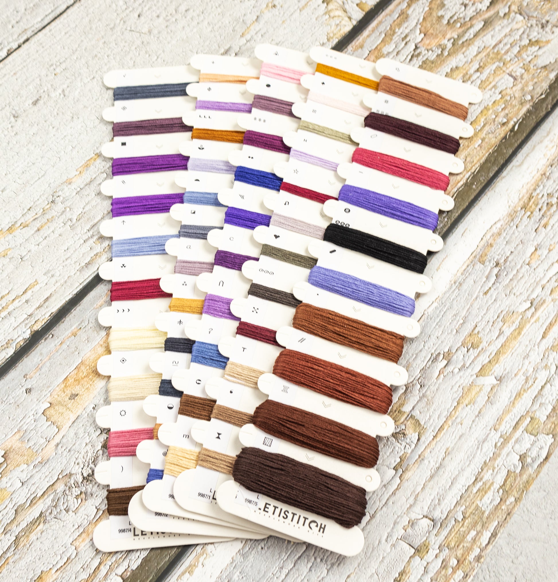 Set of embroidery threads in various colors on a wooden surface