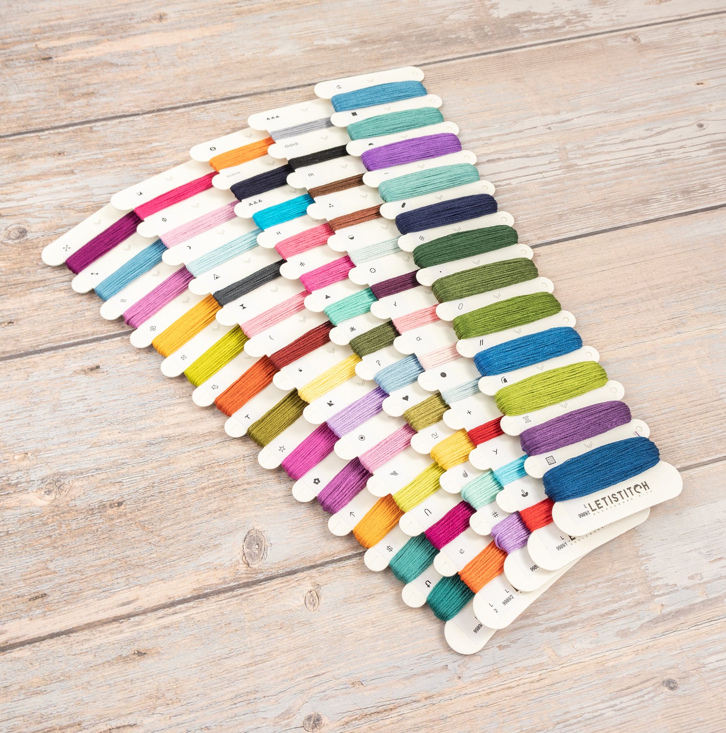Set of colorful embroidery threads on a wooden surface