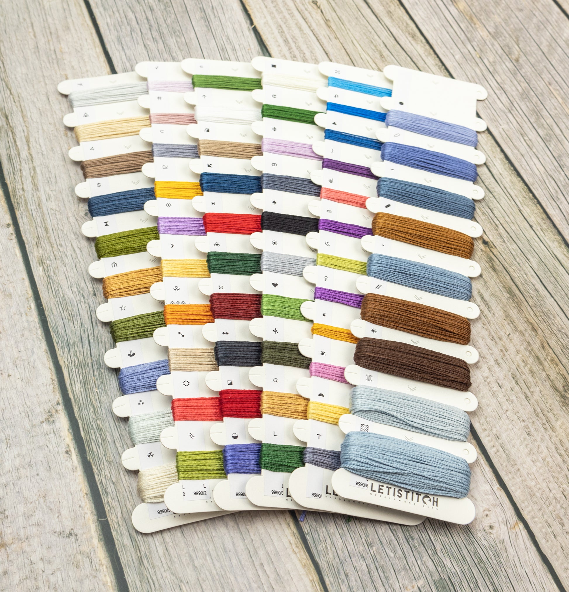 Collection of embroidery threads on a wooden surface