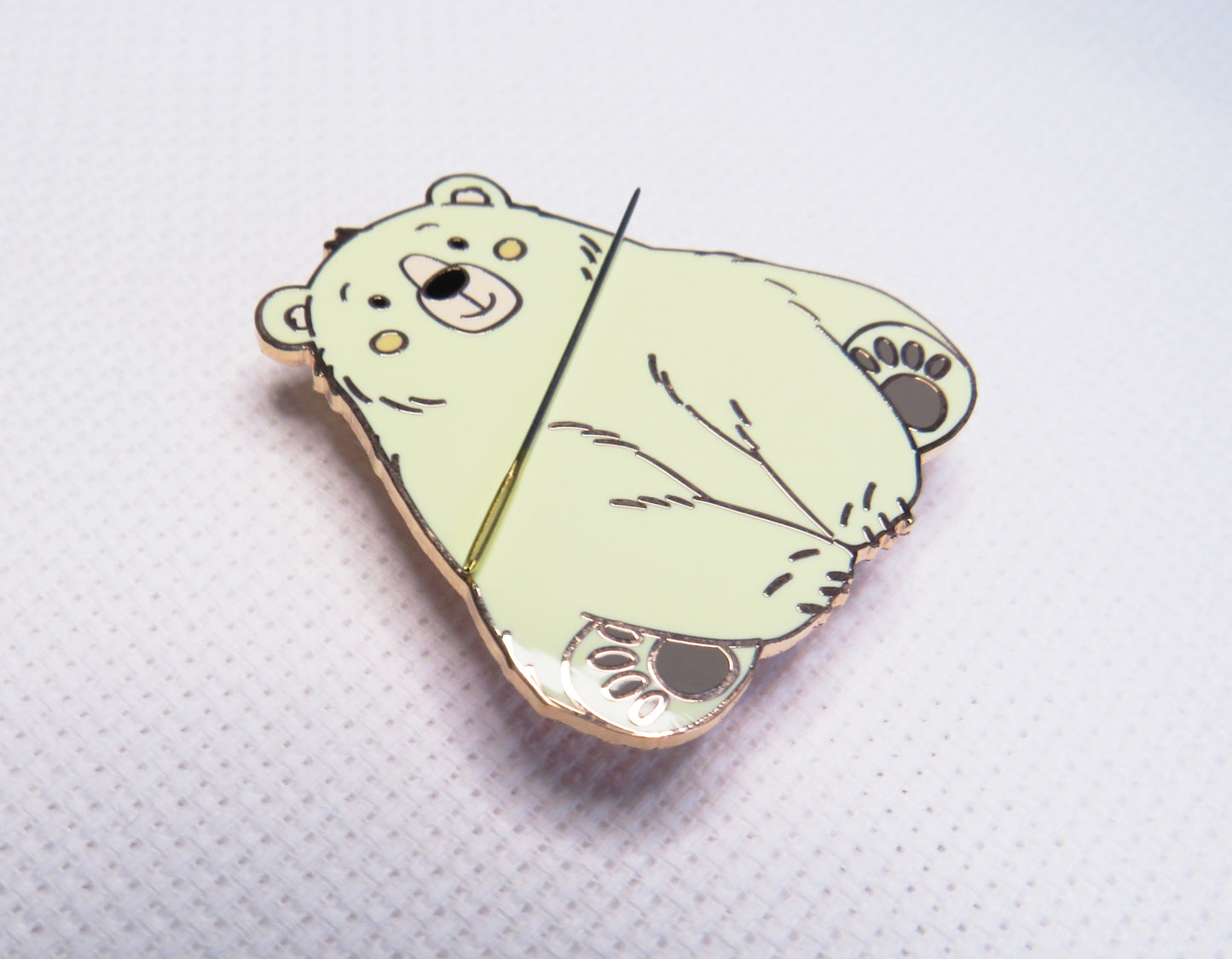 needleminder with a bear design on a textured white background