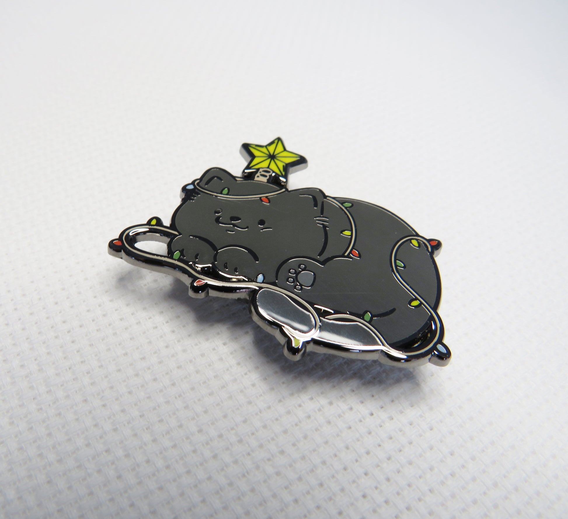 Black cat-shaped  needleminder with a star on a white background