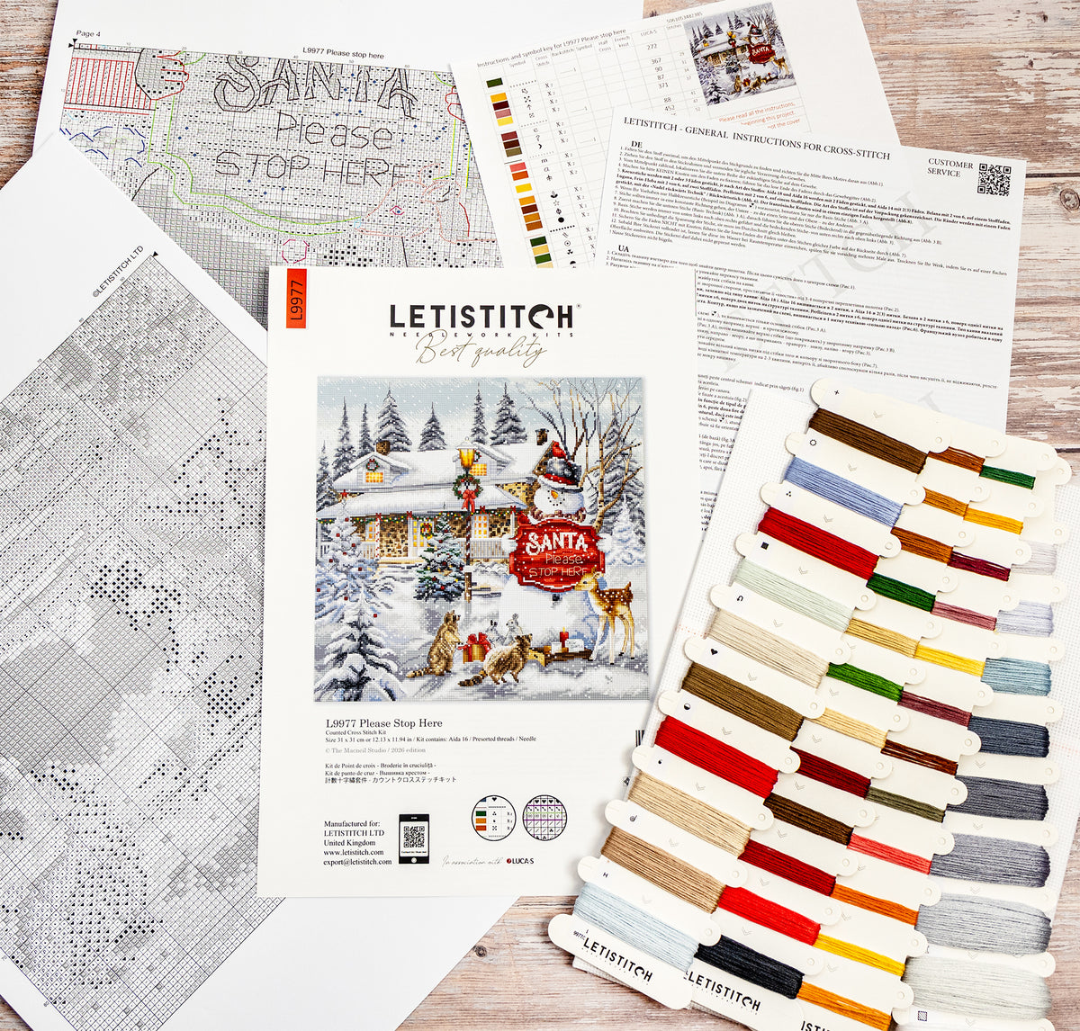 Cross-stitch kit with pattern, color chart, and threads on a wooden surface