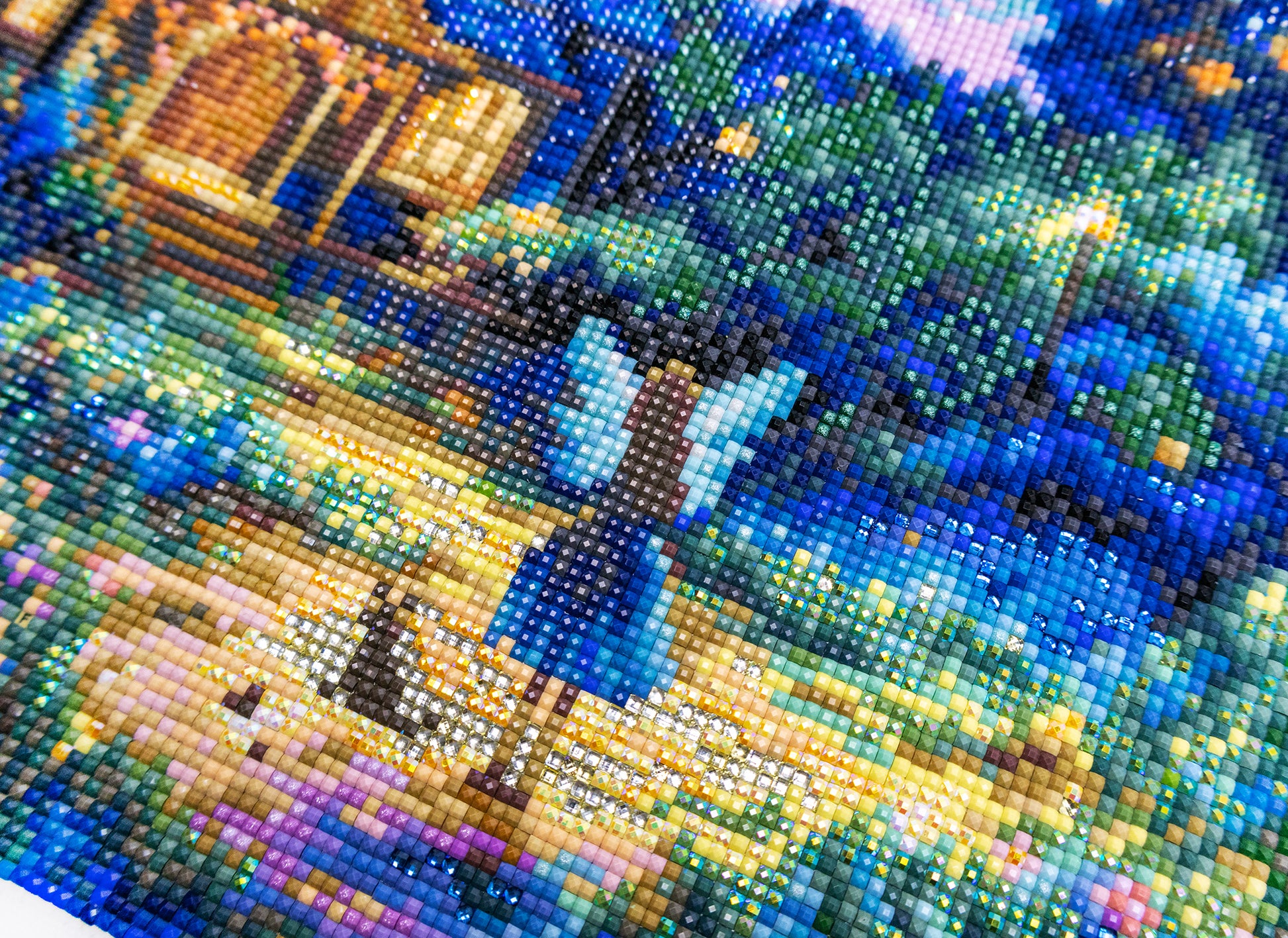 Diamond art of a person in a blue dress standing in a garden at night.