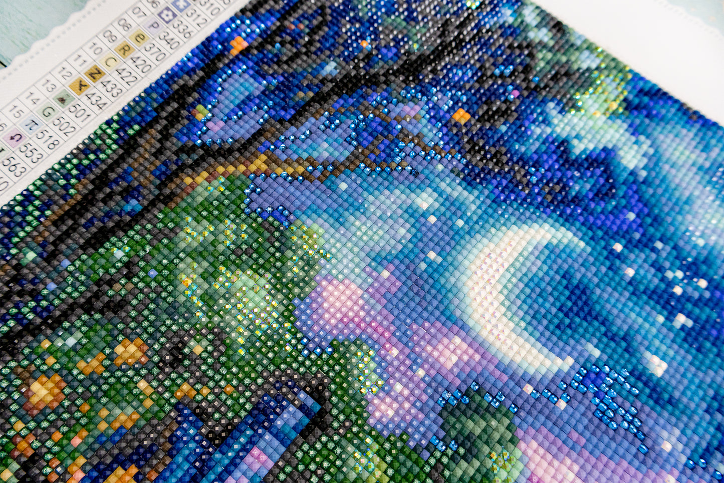 DIY diamond painting kit with a completed artwork of a night sky scene.
