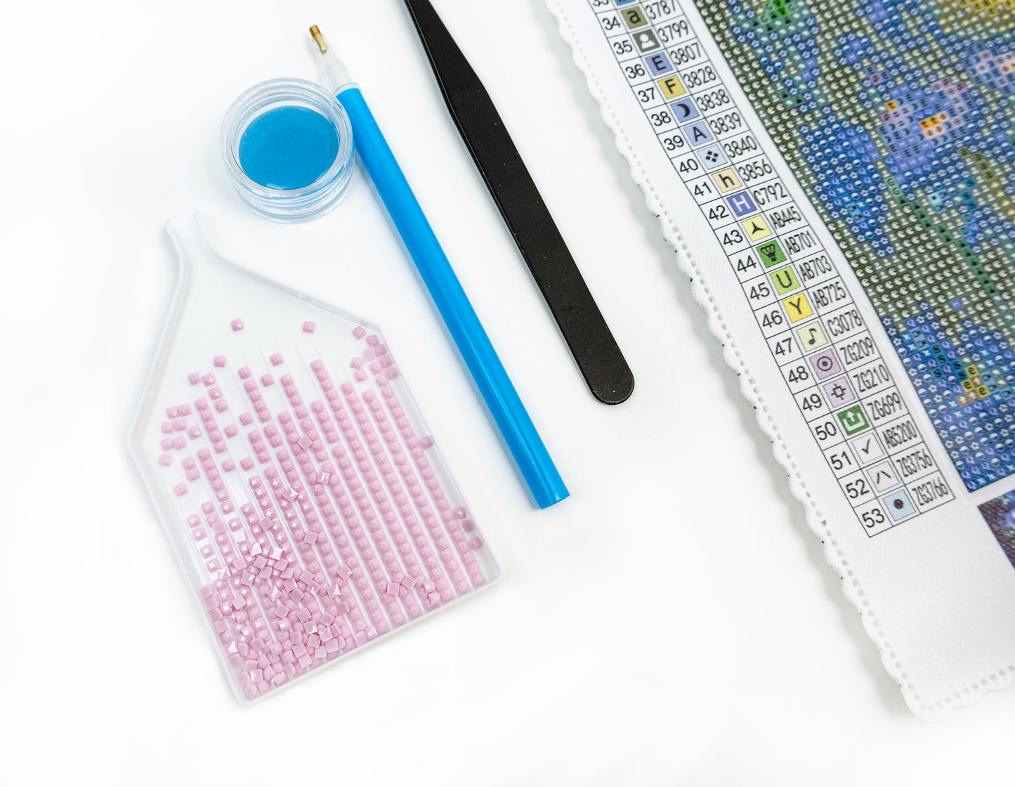 Diamond art Crafting materials including crystals, tools, and a color chart on a white background