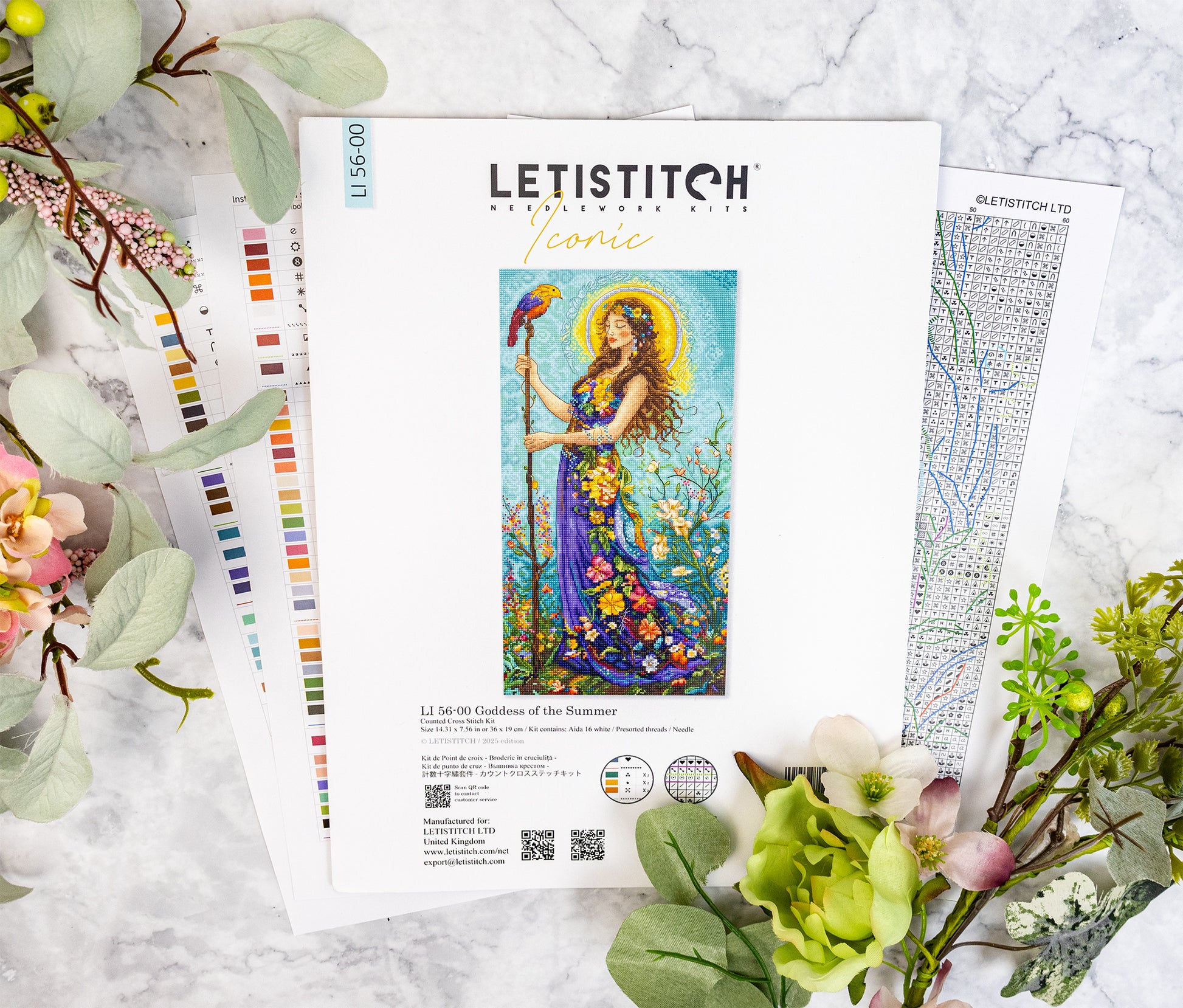Letistitch embroidery kit with colorful design on a marble surface with flowers and leaves.