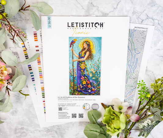 Letistitch embroidery kit with colorful design on a marble surface with flowers and leaves.