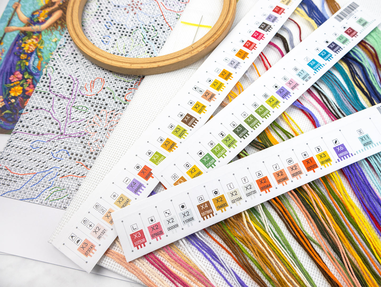 Colorful cross-stitch patterns and threads on a white surface