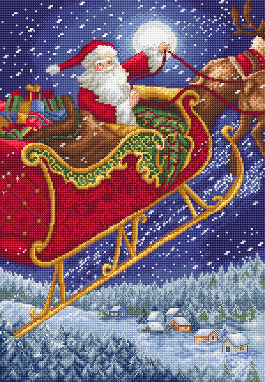 Cross-stitched depiction of Santa Claus in a sleigh with reindeer over a snowy landscape.