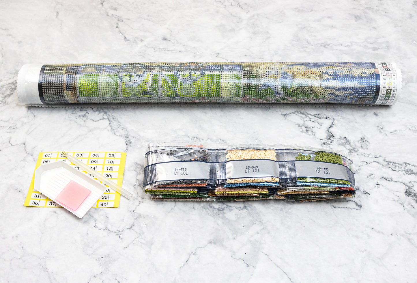 Diamond painting kit Dazzle Dots components on a marble surface