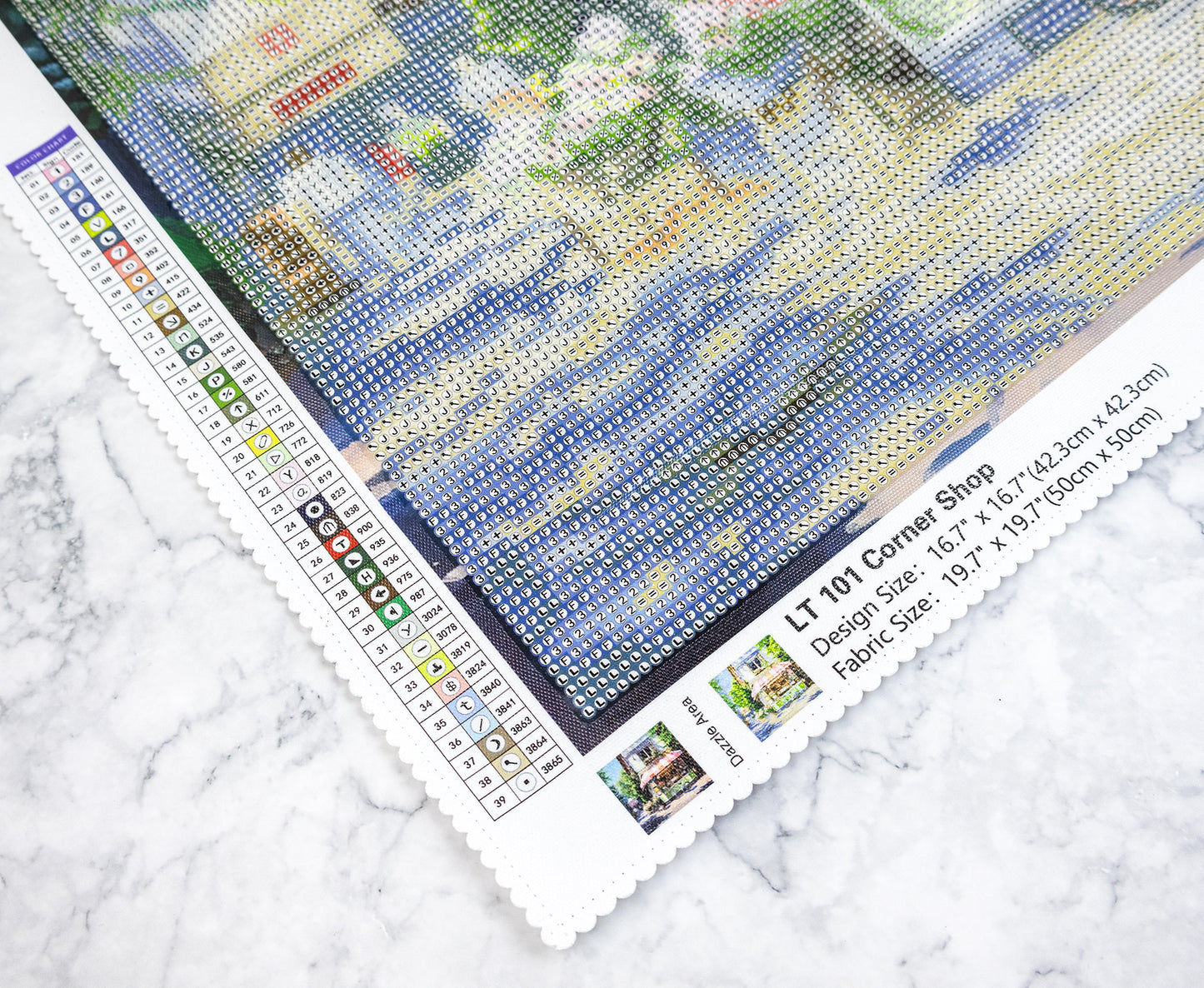 Diamond painting kit with a partially completed design on a marble surface