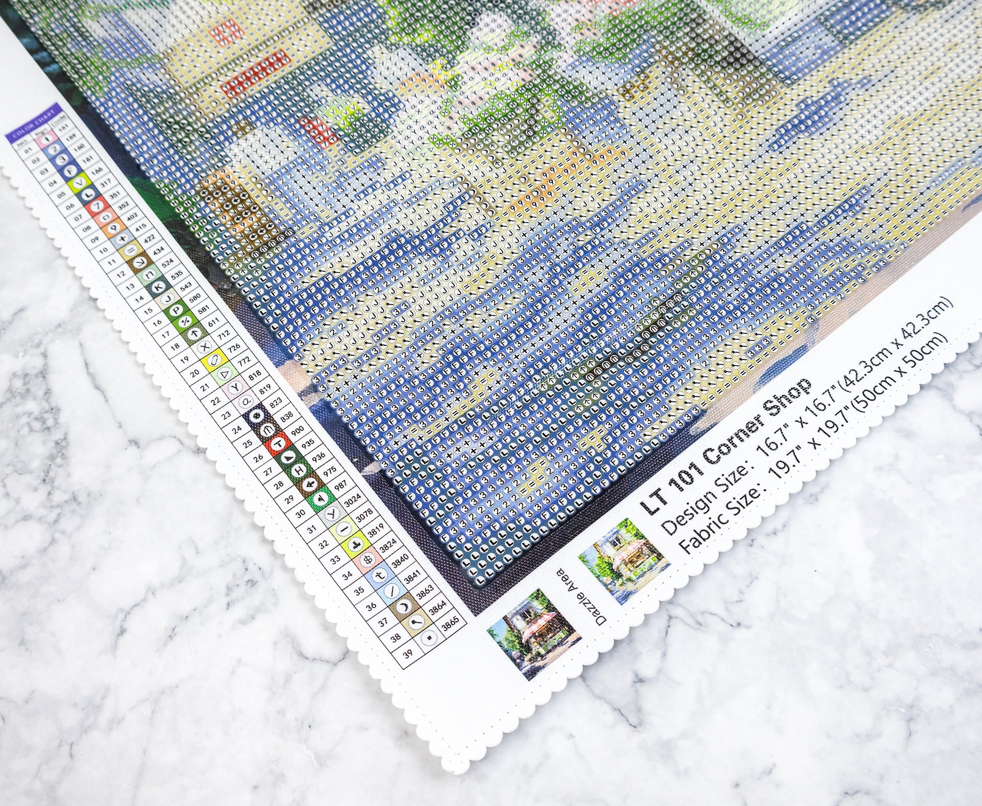 Diamond painting kit with a partially completed design on a marble surface