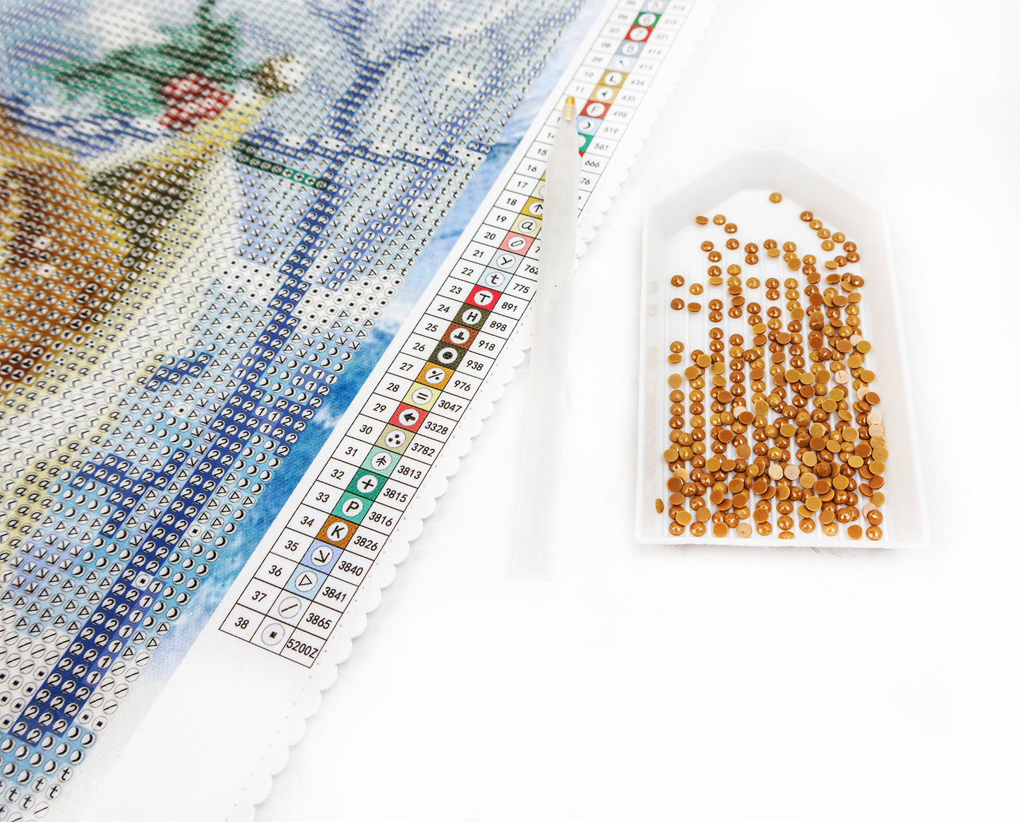 diamond art pattern with a box of beads and a needle on a white background