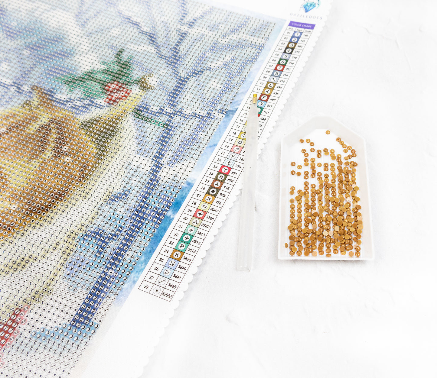 diamond painting project with a completed section and a packet of crystals on a white backgroun