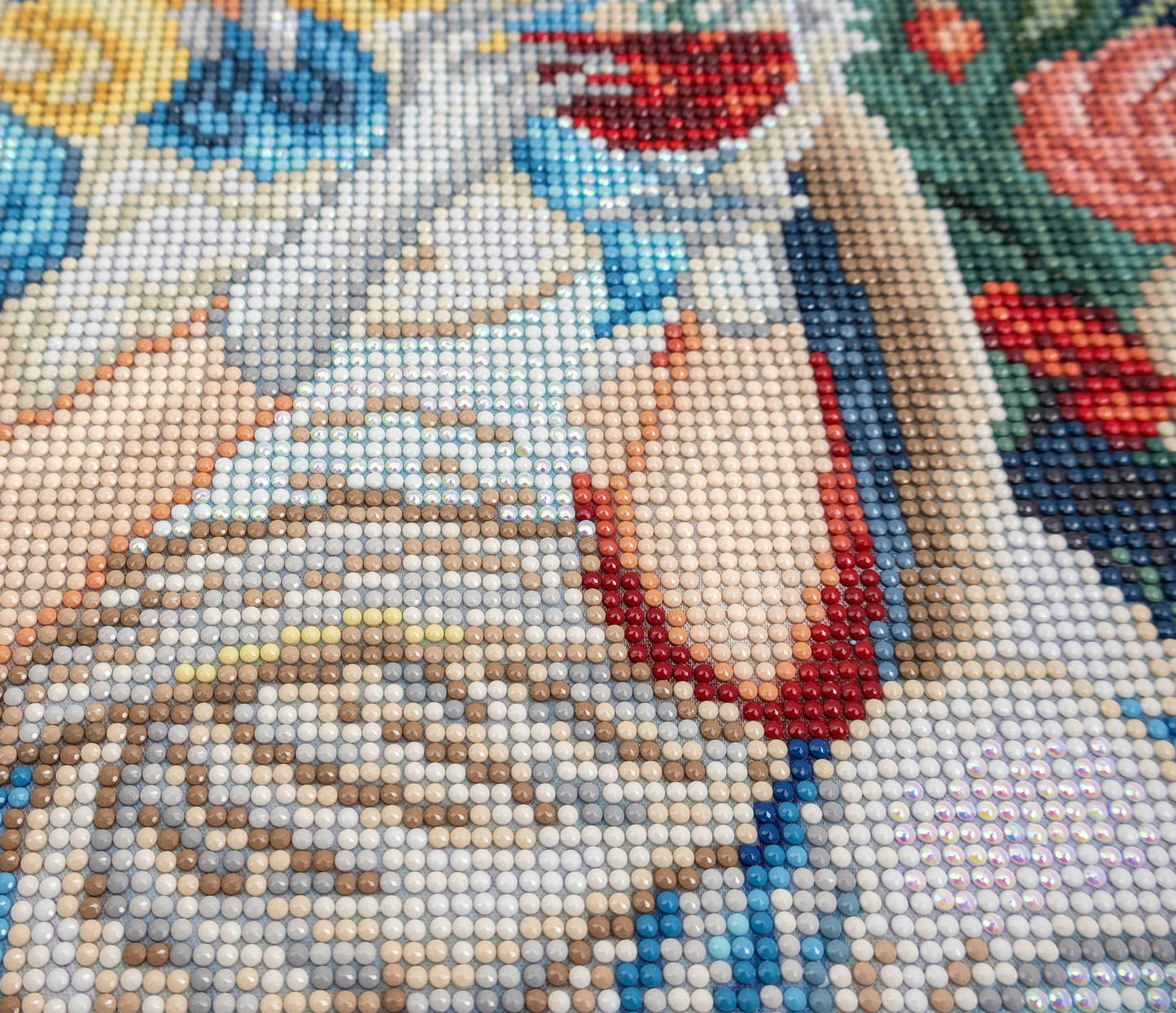 Close-up of a diamond painting with a woman's face and floral background