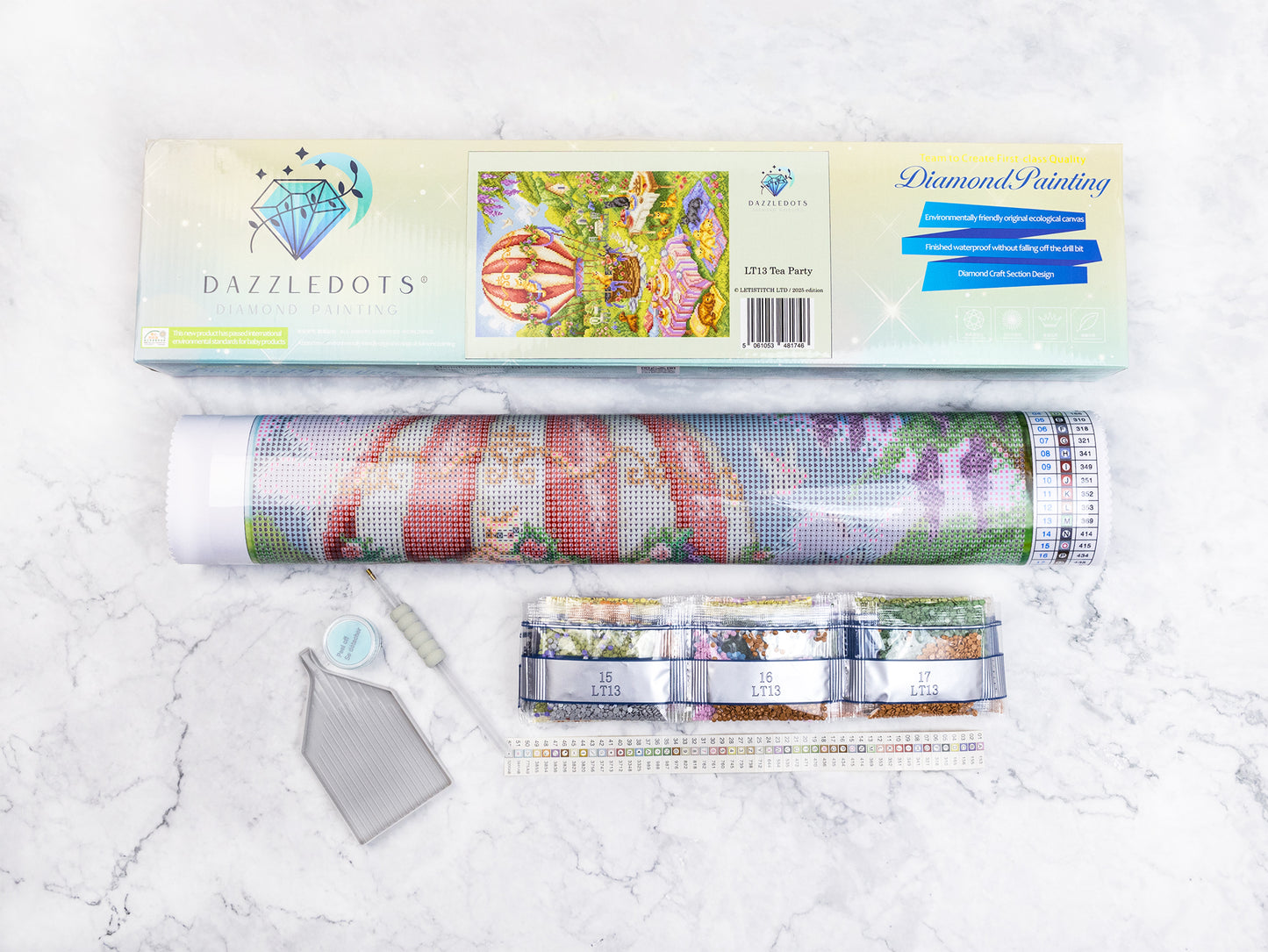 Dazzledots diamond painting kit with roll of paper and tools on a marble surface