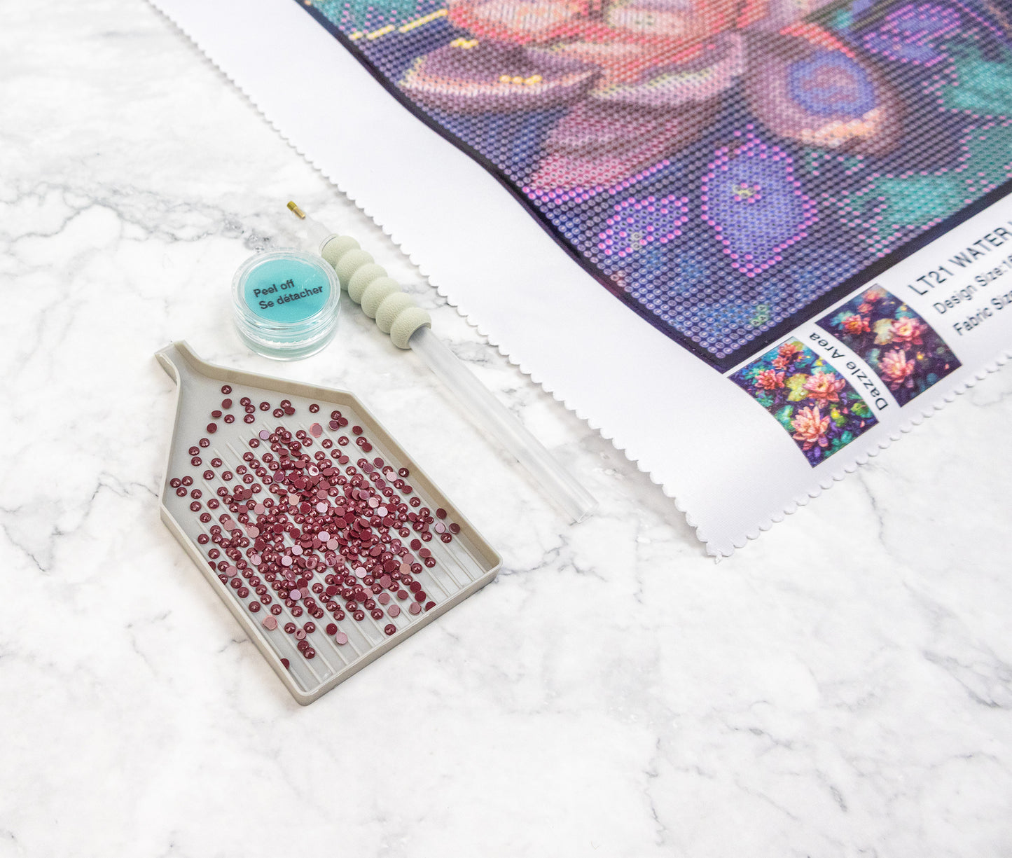 Diamond painting kit with a partially completed artwork on a white surface