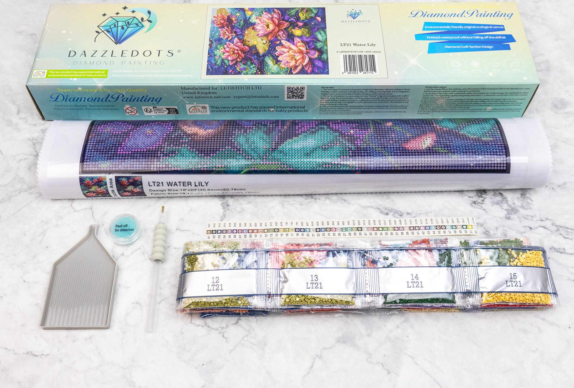 Diamond painting kit with tools on a marble surface